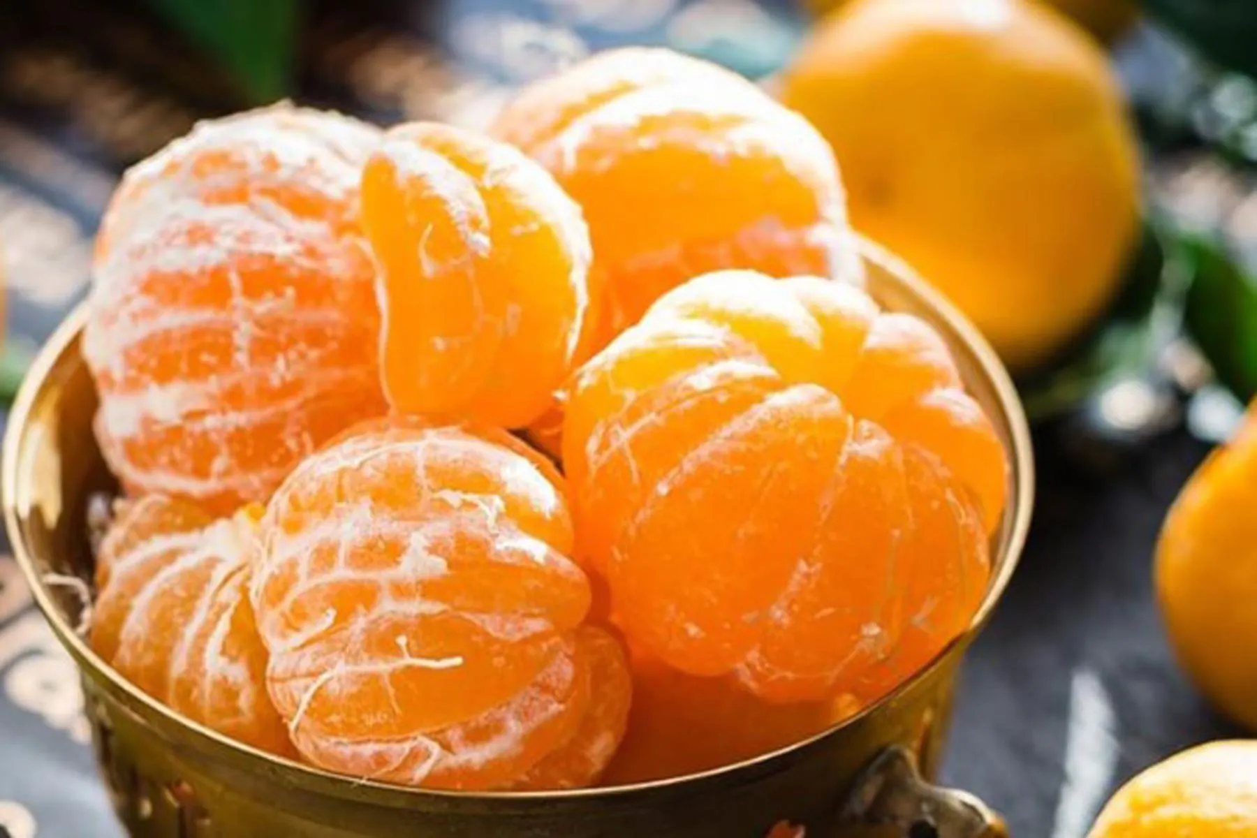 Peeled tangerines in a golden bowl